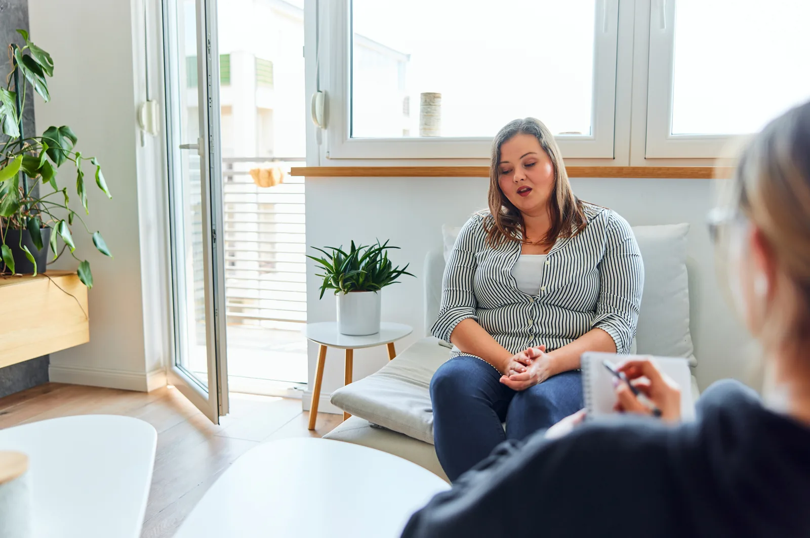 A woman talking with a counselor in a bright, welcoming room